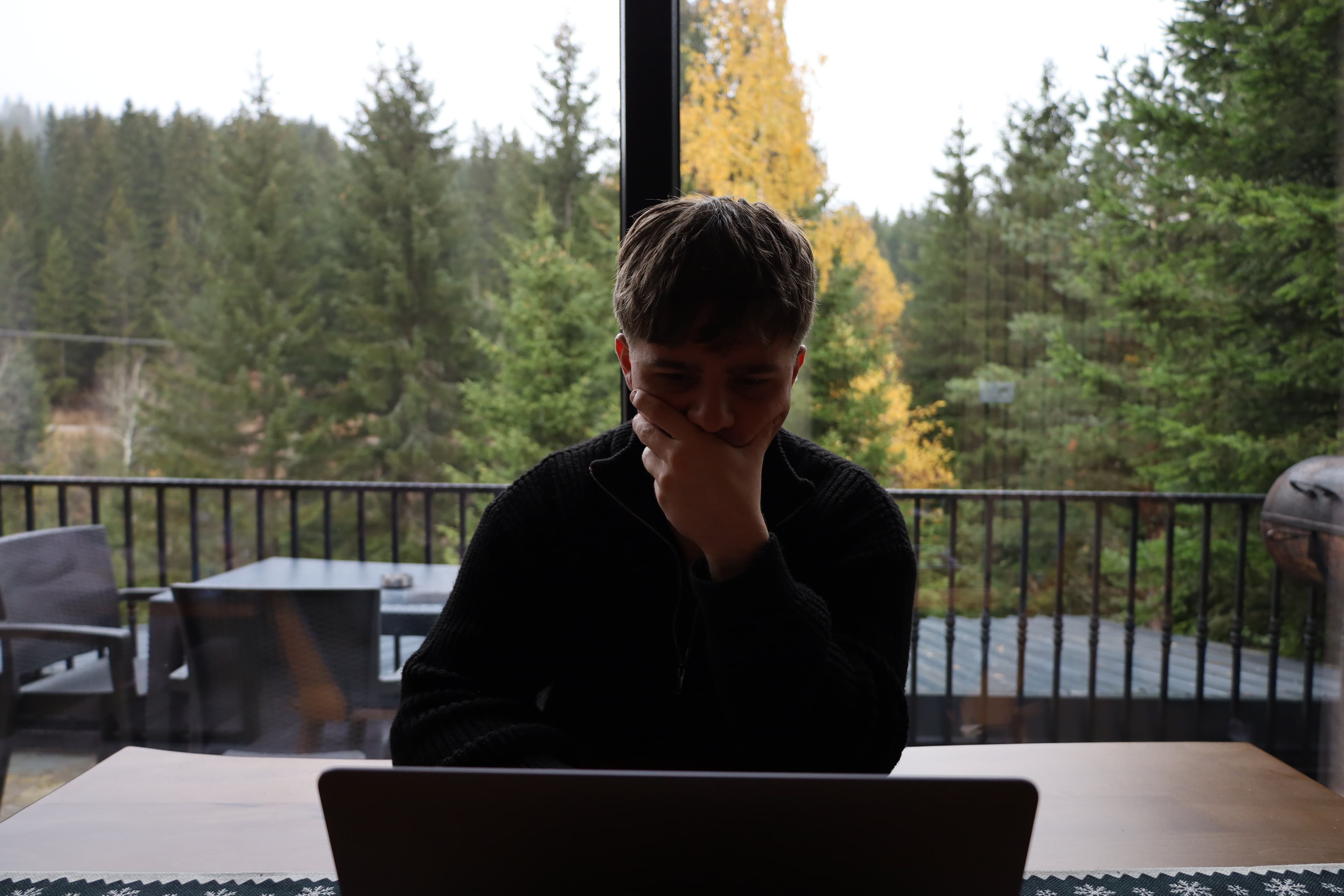 Meduard working on a laptop in a forest
